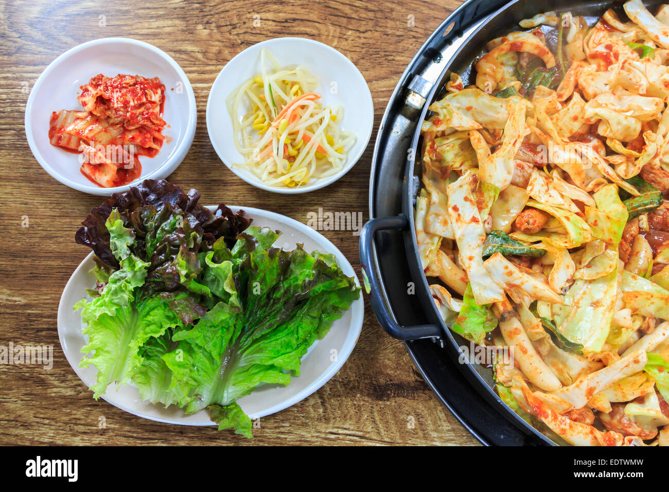 Koreanisches Essen zu komponieren, Kimchi, frischem Salat, Sojasprossen und kurz angebratenes Gemüse mit Huhn auf Holztisch Stockfoto