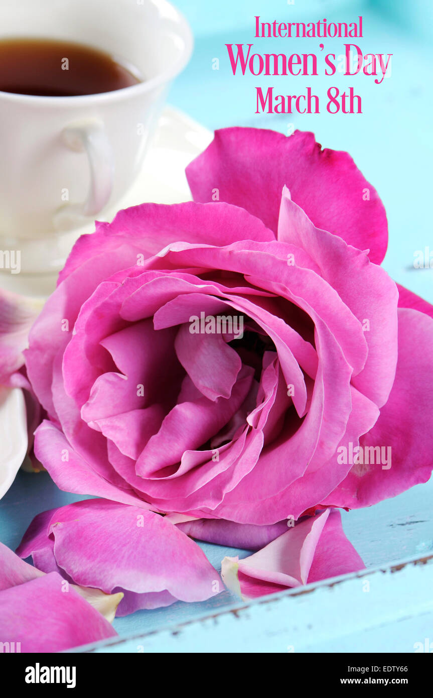 Glücklich International Womens Day Gruß mit rosa Rosen und am Nachmittag Tee Tablett auf rosa Hintergrund mit Beispieltext. Stockfoto