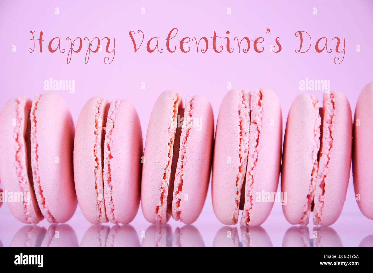 Happy Valentinstag rosa Makronen auf rosa Hintergrund mit Probe SMS Gruß. Stockfoto