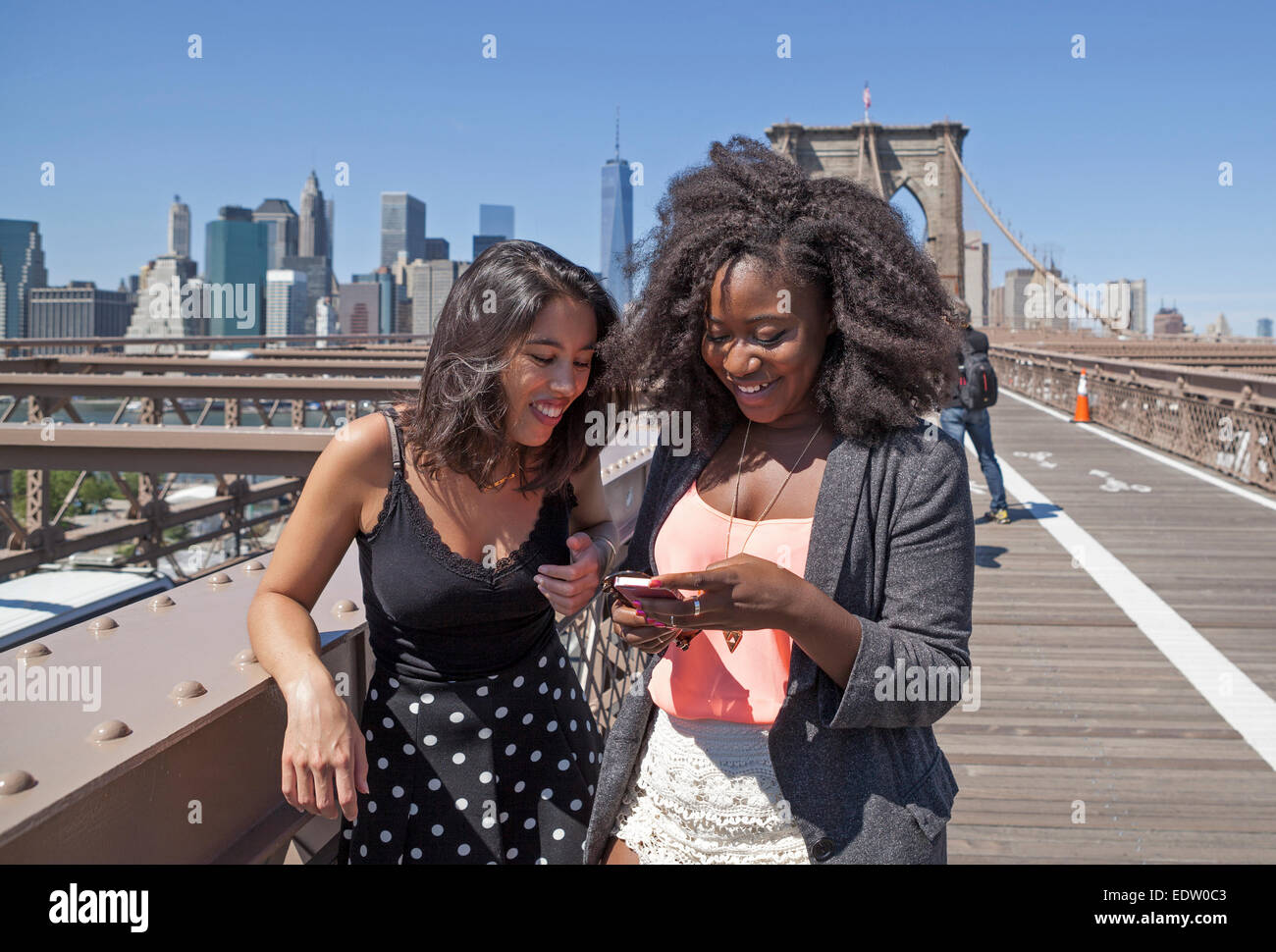 Zwei Freunde teilen sich einen Moment auf der Brooklyn Bridge in New York City. Stockfoto