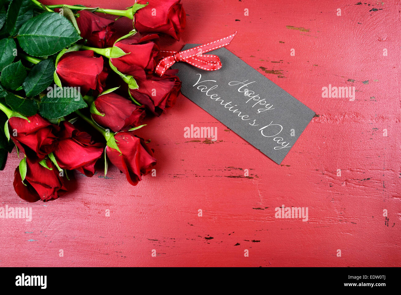 Happy Valentinstag Hintergrund mit roten Rosen mit Grußkarte auf distressed Vintage recycelten Holztisch. Stockfoto