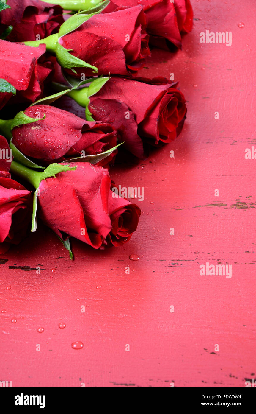 Happy Valentinstag Hintergrund mit roten Rosen hautnah auf distressed Vintage recycelten Holztisch. Vertikale. Stockfoto