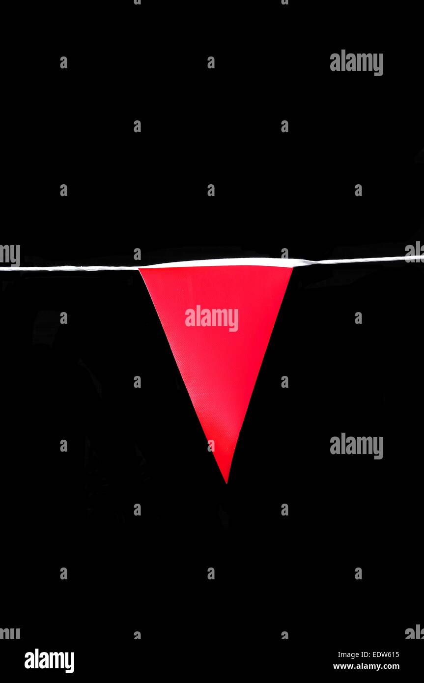 Rote Wimpel Flagge vor einem schwarzen Hintergrund. Stockfoto