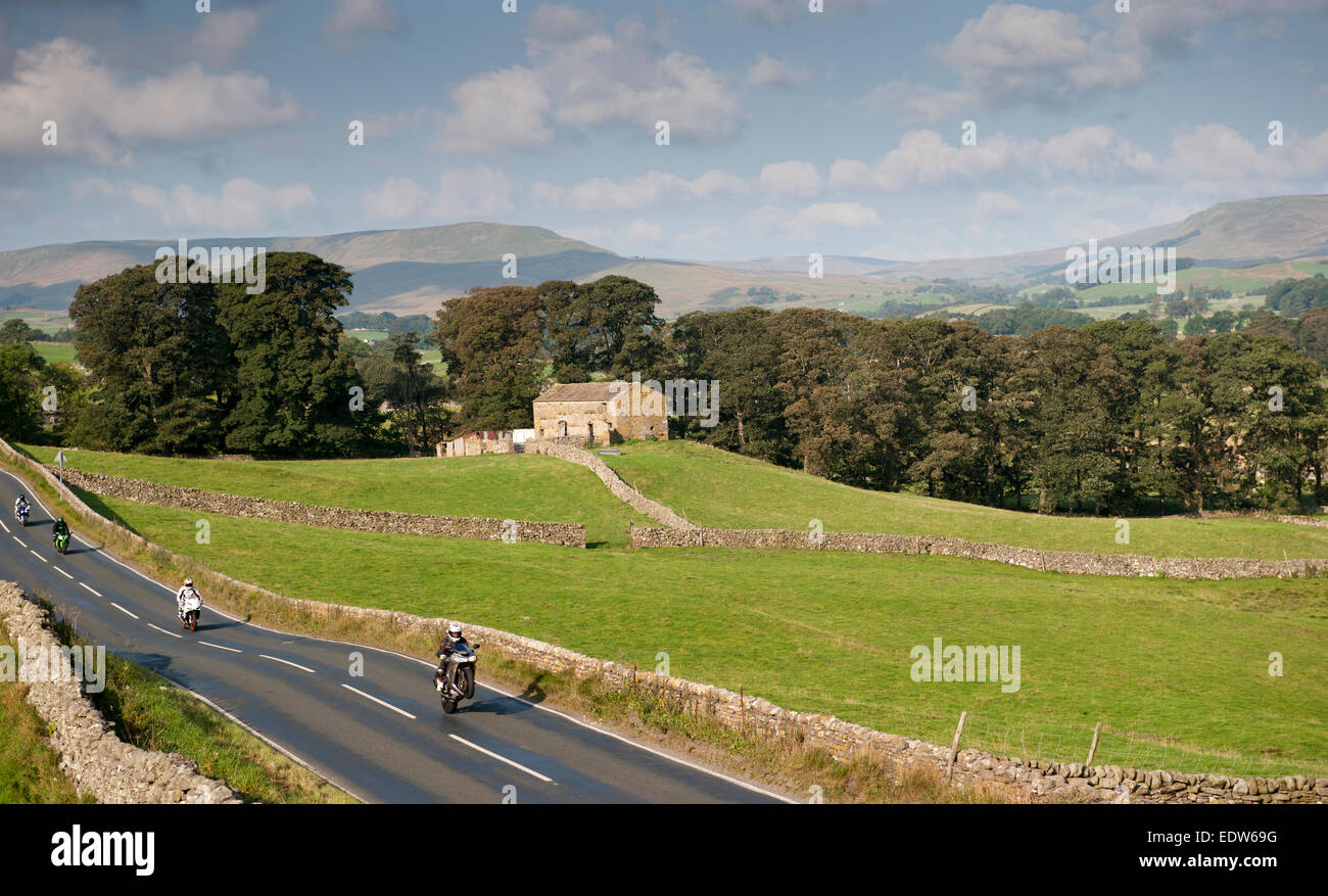 Motorradfahrer auf der Landstraße zu beschleunigen und einen Wheelie zu tun. UK Stockfoto