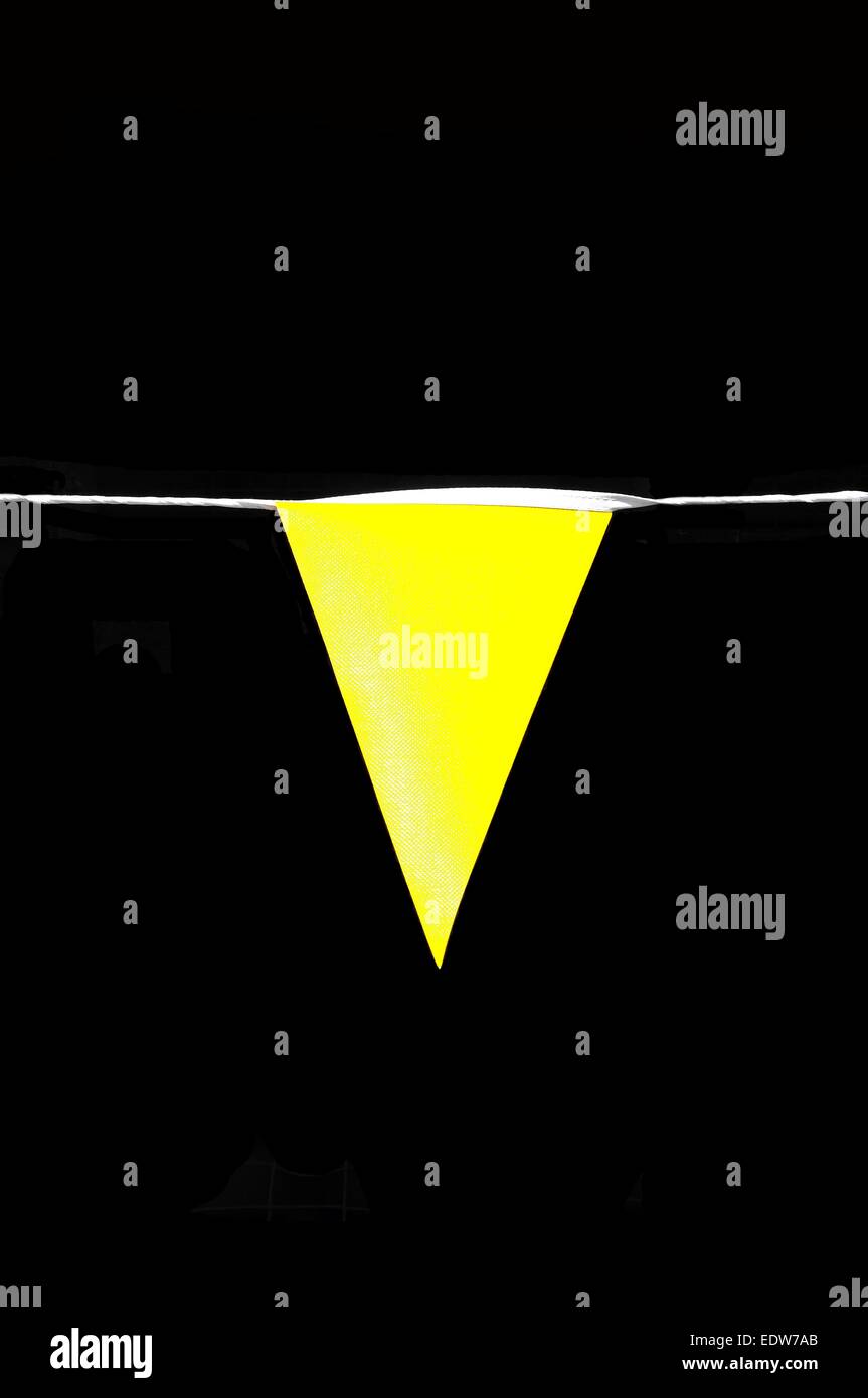 Gelbe Wimpel Flagge vor einem schwarzen Hintergrund. Stockfoto