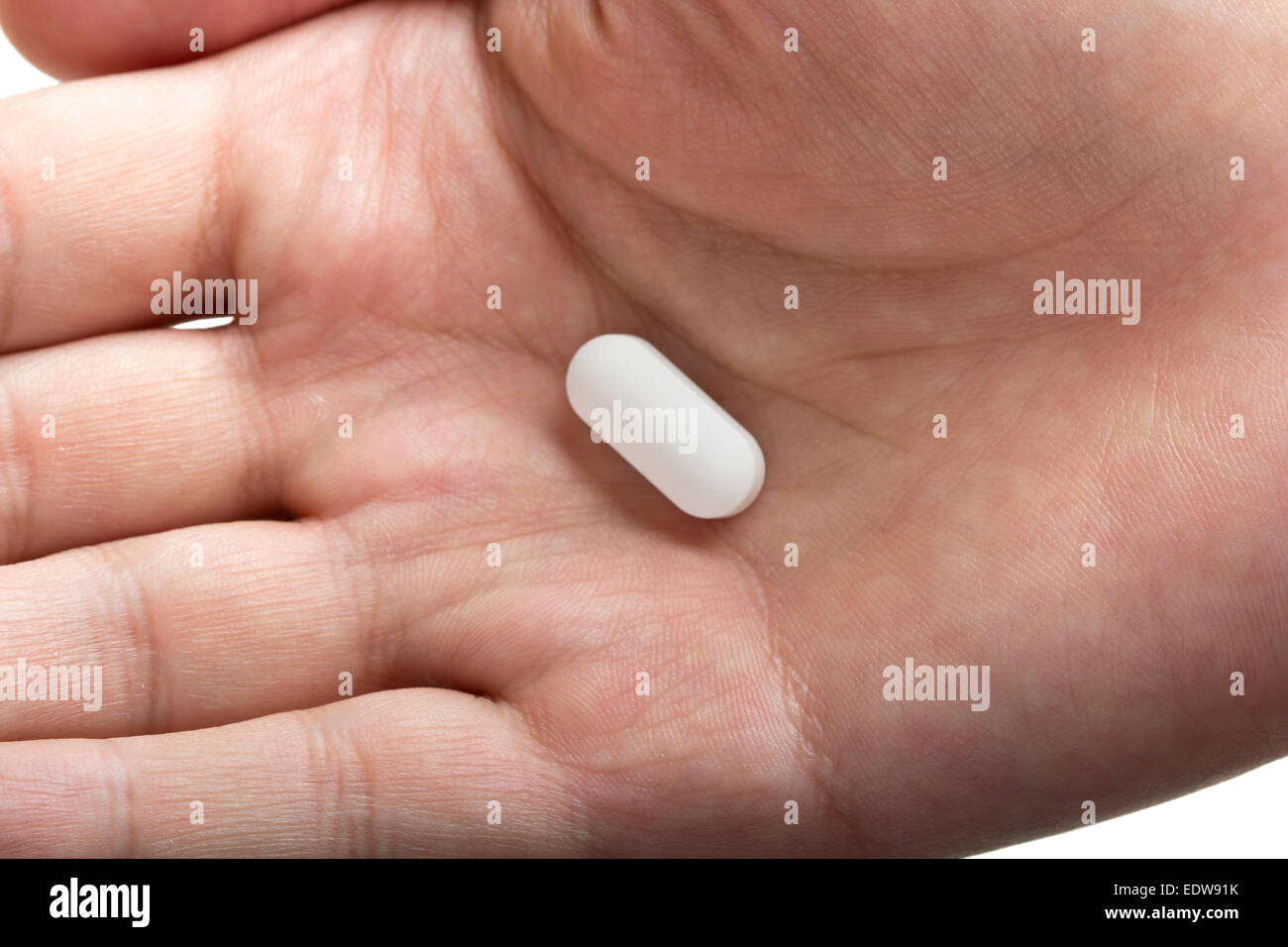Nahaufnahme von einer menschlichen Hand mit einer Pille, isoliert Stockfoto
