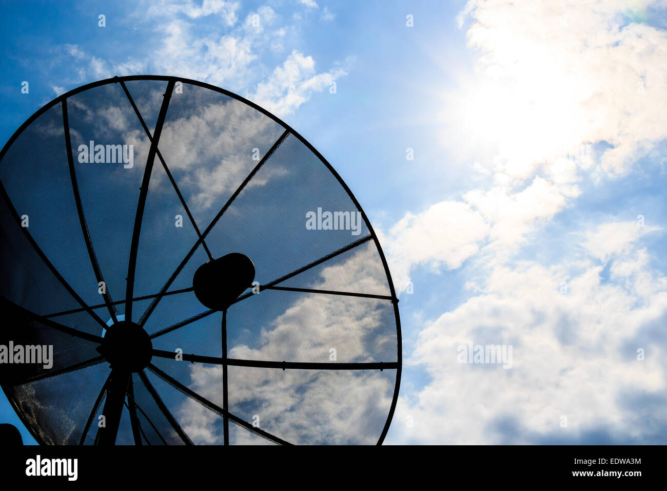 Satellitenschüssel und bewölkter Himmel mit Sonnenstrahl Nachmittag (Silhouette-Stil) Stockfoto