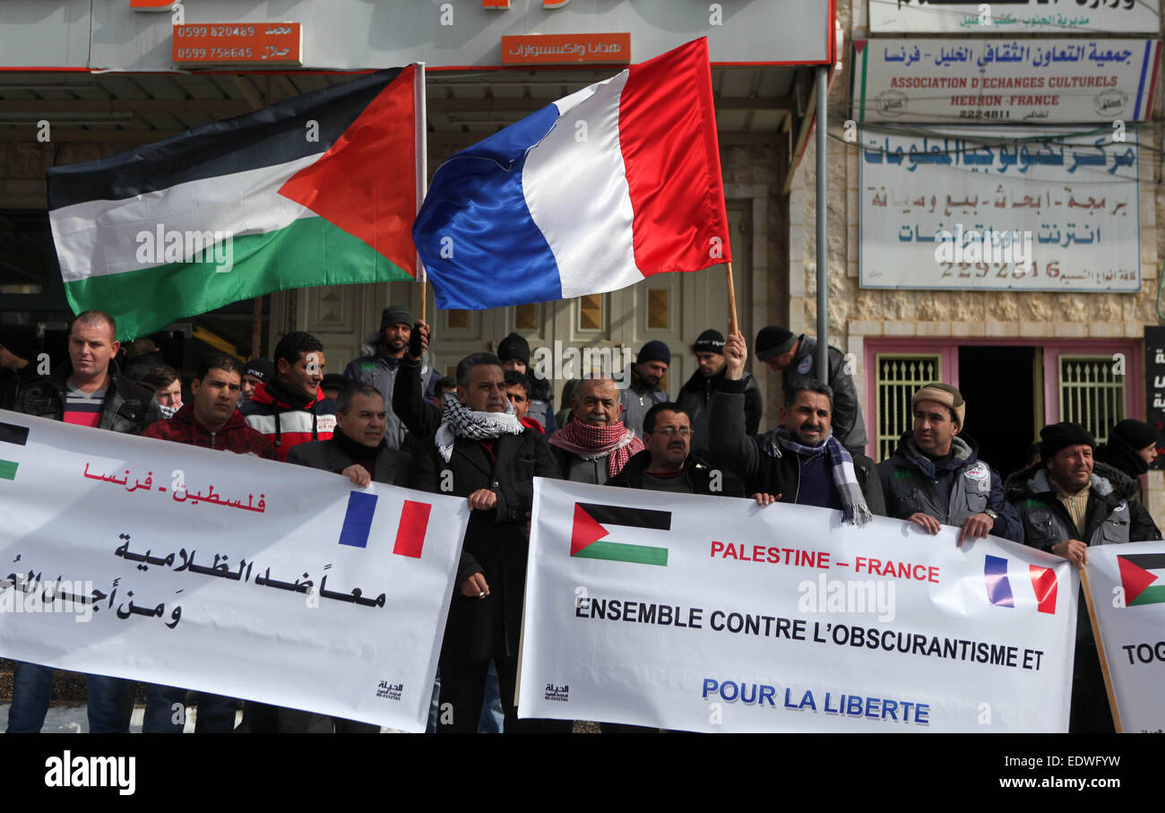 Hebron, Westjordanland, Palästinensische Gebiete. 10. Januar 2015. Palästinenser und Französisch Demonstranten Welle ihre Nationalflaggen während einer Versammlung vor der Hebron-Frankreich-Verein für kulturellen Austausch in der Westbank-Stadt Hebron auf wie sie gegen den islamistischen Angriff von zwei bewaffneten Männern, 12 Menschen getötet, in französischen satirischen Zeitschrift Hebdos Redaktion in Paris in dieser Woche zeigen. Bildnachweis: ZUMA Press, Inc./Alamy Live-Nachrichten Stockfoto