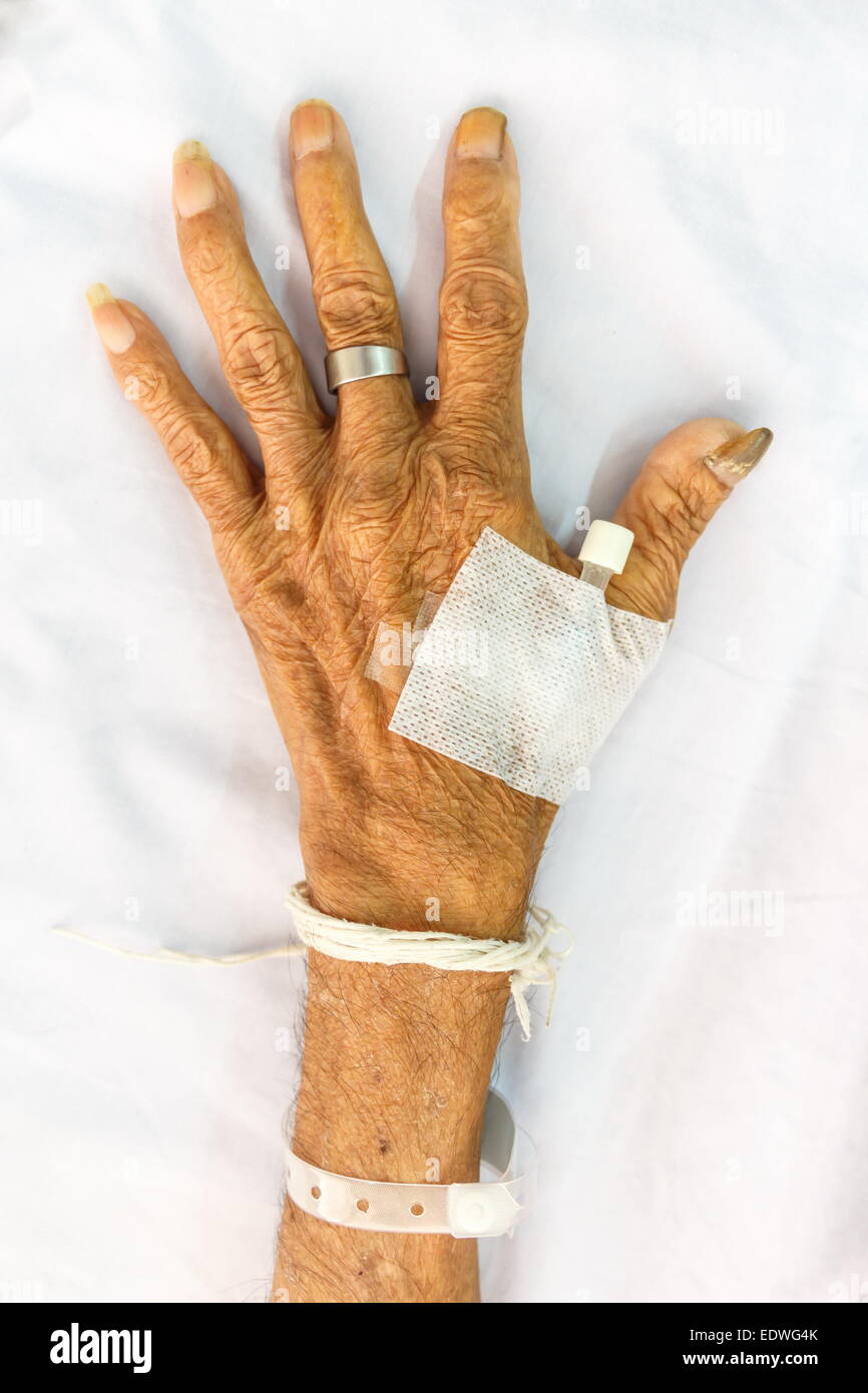 Hand der alten Patienten mit Stecker auf Bett im Krankenhaus Stockfoto