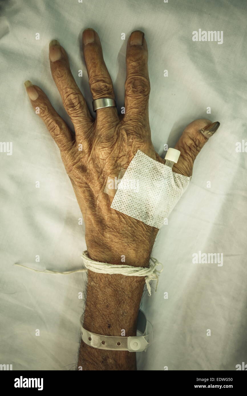 Hand der alten Patienten mit Stecker auf Bett im Krankenhaus (Vignette-Stil) Stockfoto