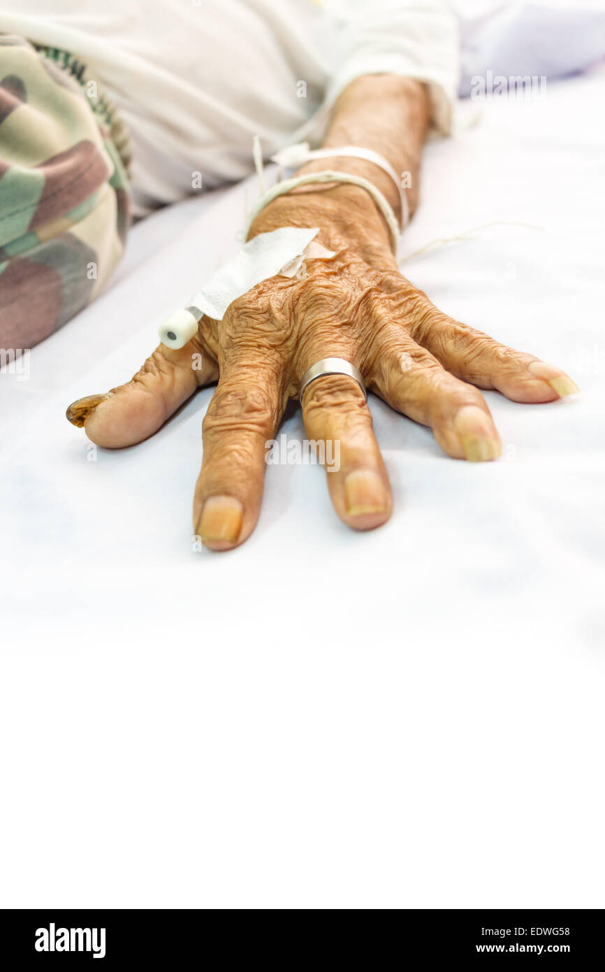 Hand der alten Patienten mit Stecker auf Bett im Krankenhaus und leeren Bereich am unteren Seite für Füllung text Stockfoto