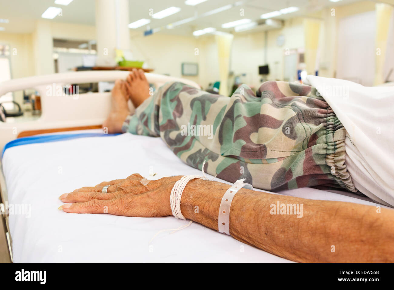 ältere Patienten hinlegen auf Bett in Notaufnahme im ländlichen Krankenhaus, Thailand Stockfoto