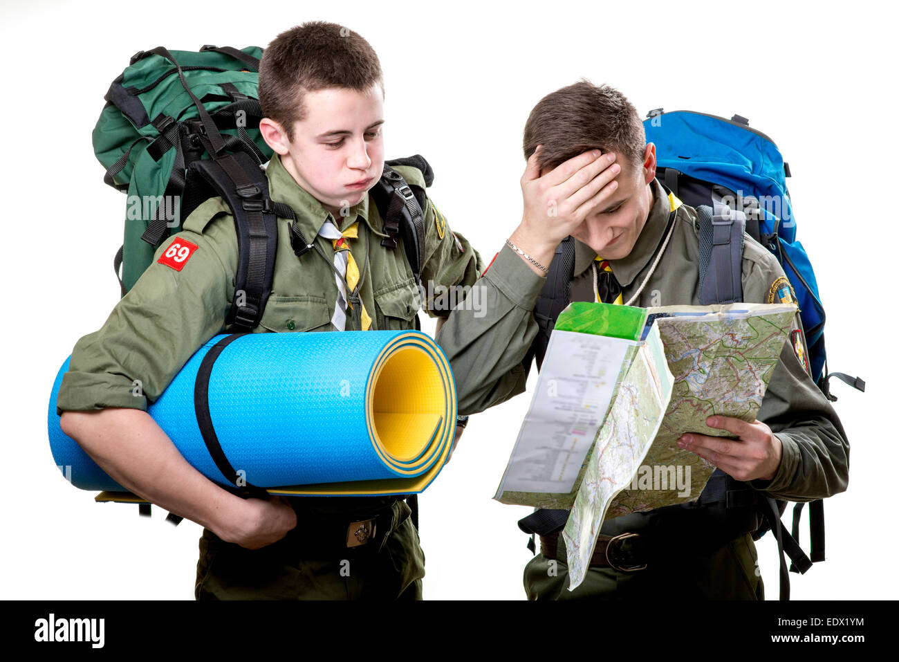 Zwei junge Pfadfinder jungen mit Schlafsack und Rucksäcke im Besitz der  Karte isoliert auf weißem Hintergrund Stockfotografie - Alamy