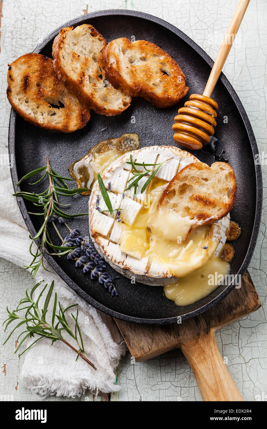 Gebackener Camembert Käse mit geröstetem Brot auf gusseisernen Pfanne Stockfoto