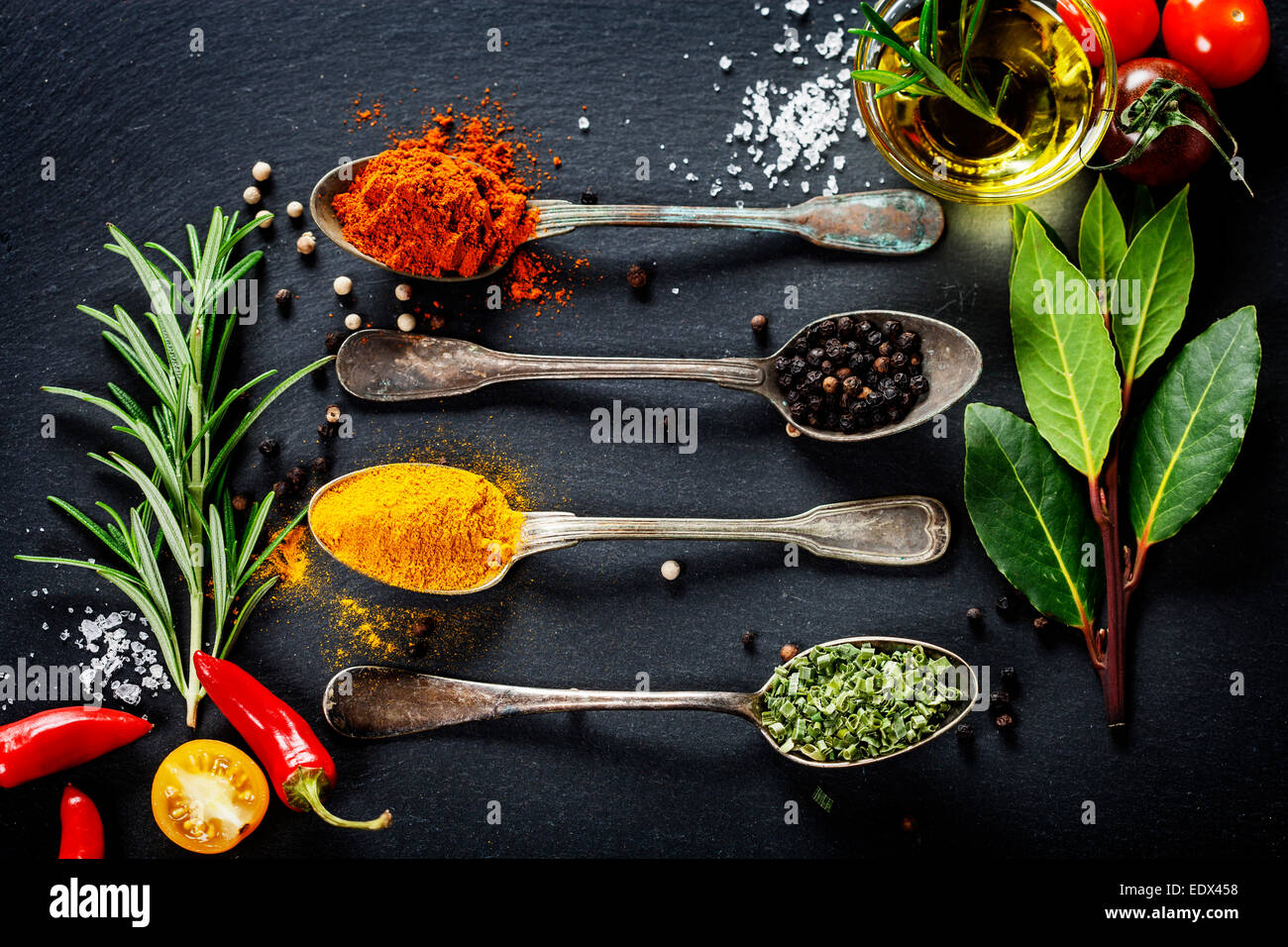 Kräuter und Gewürze Auswahl - Kräuter und Gewürze, alte Metalllöffel und Schiefer Hintergrund - kochen, gesunde Ernährung Stockfoto