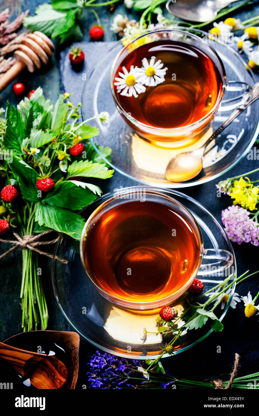 Kräutertee mit Honig, wilde Beeren und Blumen auf hölzernen Hintergrund Stockfoto