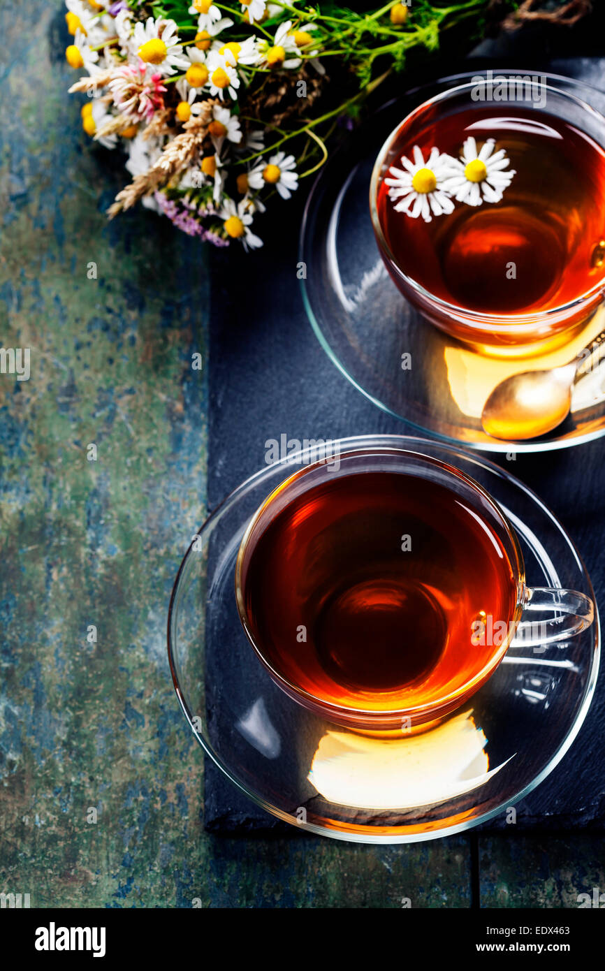 Kräutertee mit Honig, wilde Beeren und Blumen auf hölzernen Hintergrund Stockfoto