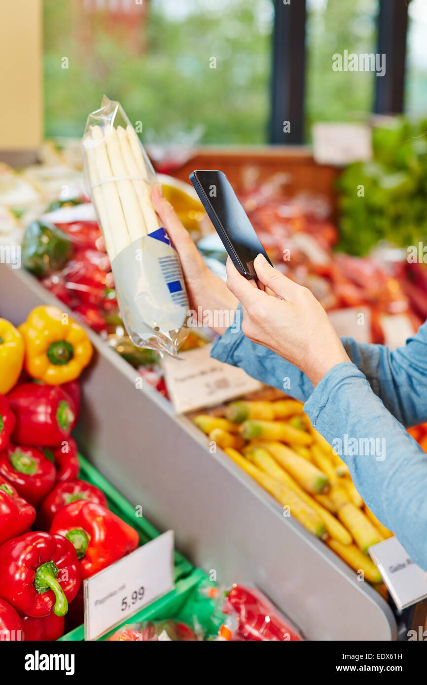 Kunden im Supermarkt Barcode eine Paket-Spargel mit seinem Smartphone Scannen Stockfoto