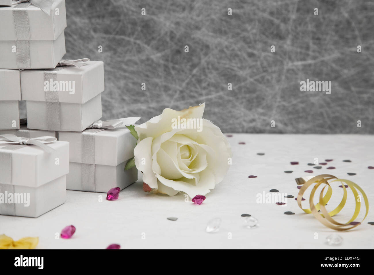 Hochzeit Gunst Boxen auf eine weiße Tischdecke mit goldene Bänder, Herz Bögen, Silber-Konfetti und kleinen Diamanten Tischdeko Stockfoto