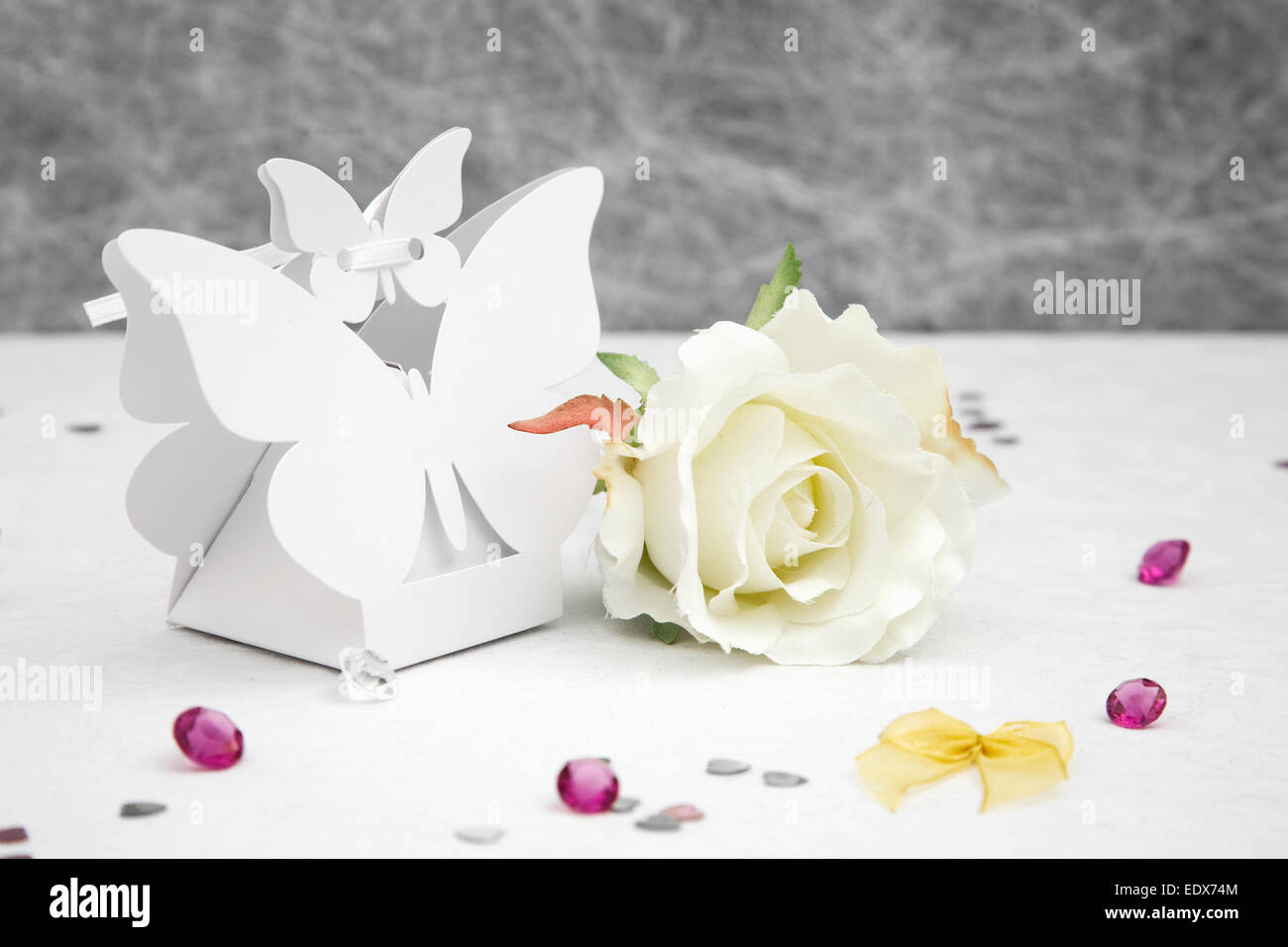 Gunst Schmetterling Form Felder auf einer weißen Tischdecke mit Bögen, silbernes Herz Konfetti und kleinen Diamanten Tischdeko Hochzeit Stockfoto