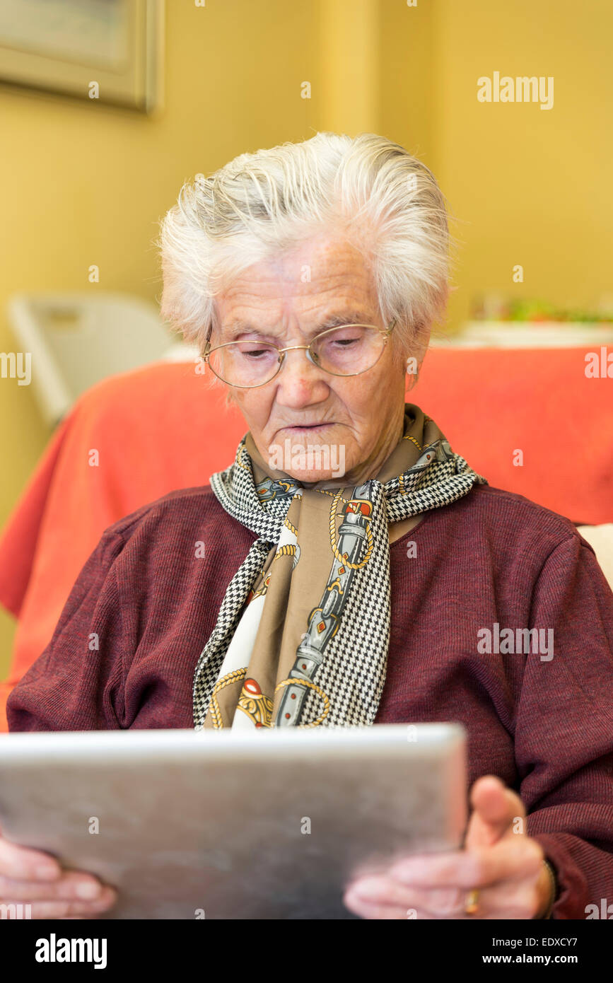 Oma lernen, eine Tablette für die geschäftliche Nutzung Stockfoto