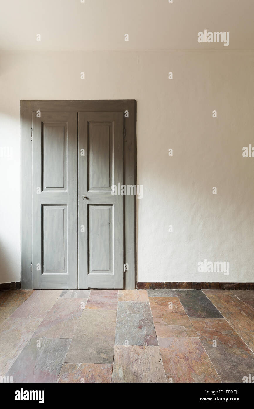 geschlossener Tür in einem rustikalen Haus, Steinboden Stockfoto