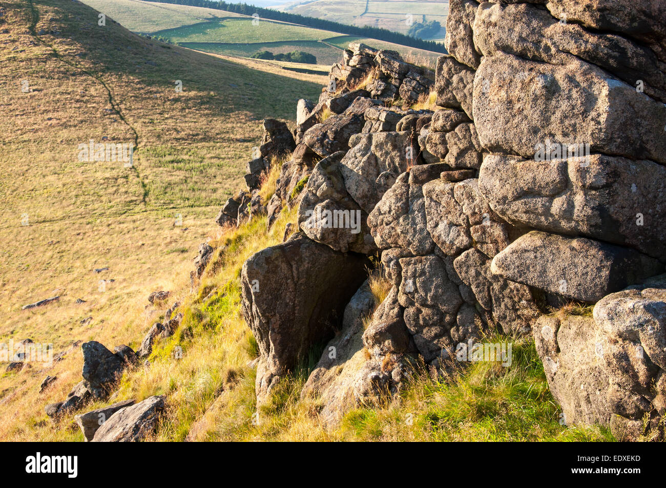 Gritstone Felsen auf dem Gipfel des Crook Hill im Peak District, Derbyshire. Einen angenehmen Abend Sommer Sonnenlicht. Stockfoto