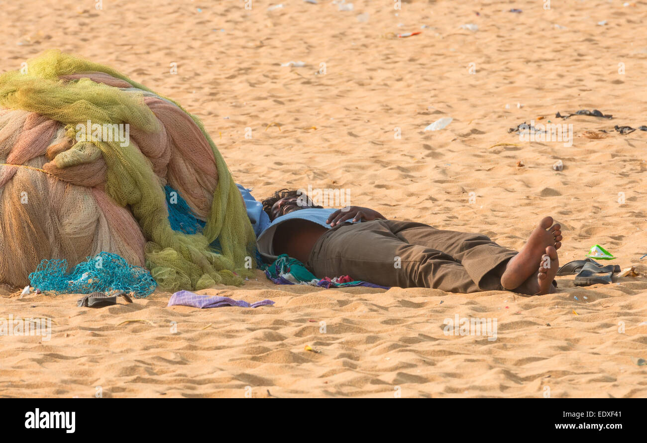 CHENNAI, Indien - Februar 10: Ein unbekannter Mann schläft auf dem Sand in der Nähe der Marina Beach am 10. Februar 2013 in Chennai, Indi Stockfoto