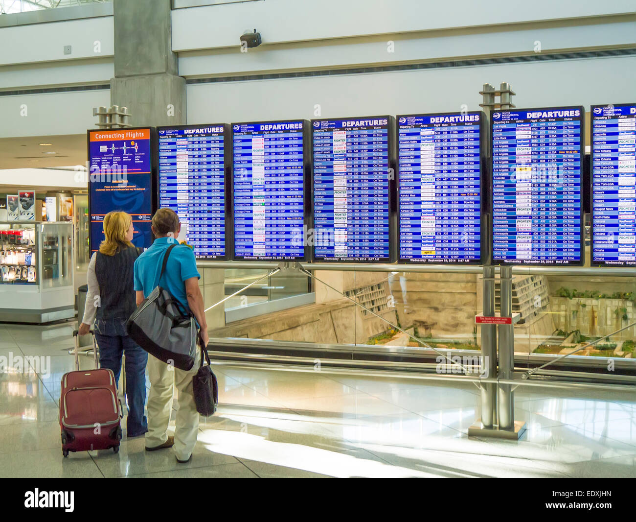 Paar auf der Suche bei Flug Informationstafel im Flughafen-terminal Stockfoto