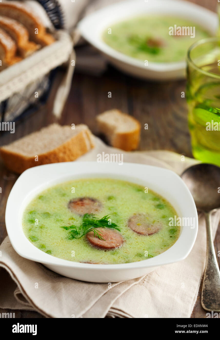 Grüne Erbsensuppe mit Wurst Stockfoto