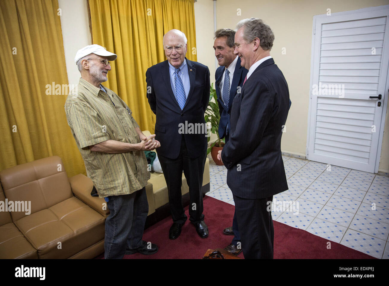 Alan Gross grüßt Patrick Leahy, D -Vt., Sen. Jeff Flake, R-AZ, Sen.and Rep Chris Van Hollen, D -MD auf einem Flughafen in der Nähe von Havanna, Kuba, 17. Dezember 2014. Gross wurde nach 5 Jahren in einem kubanischen Gefängnis freigelassen. Stockfoto