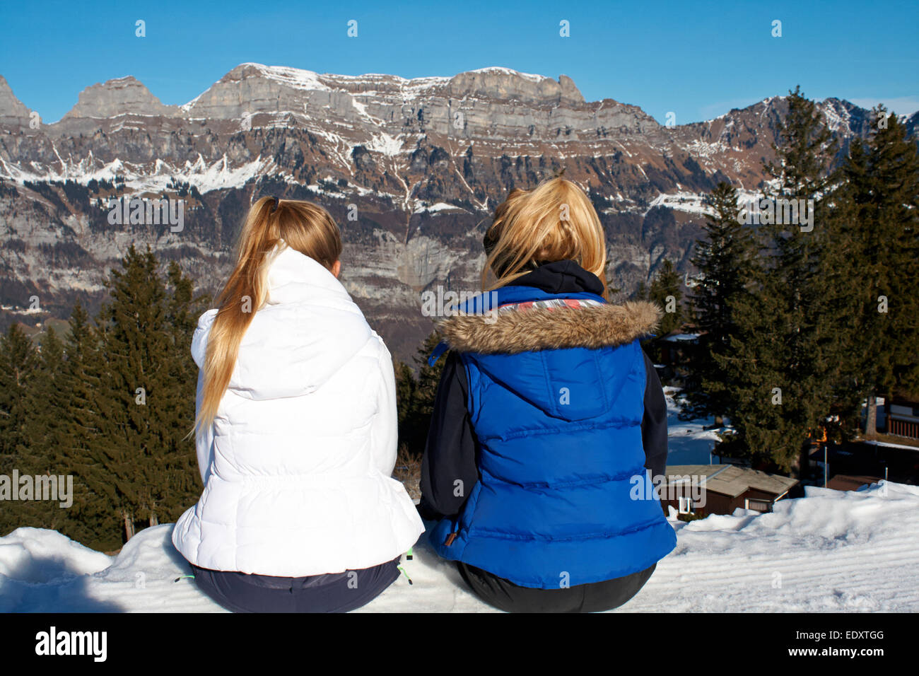 zwei blonde behaarte Teenager sitzen in der Ansicht auf einen Skiurlaub in der Schweiz Stockfoto