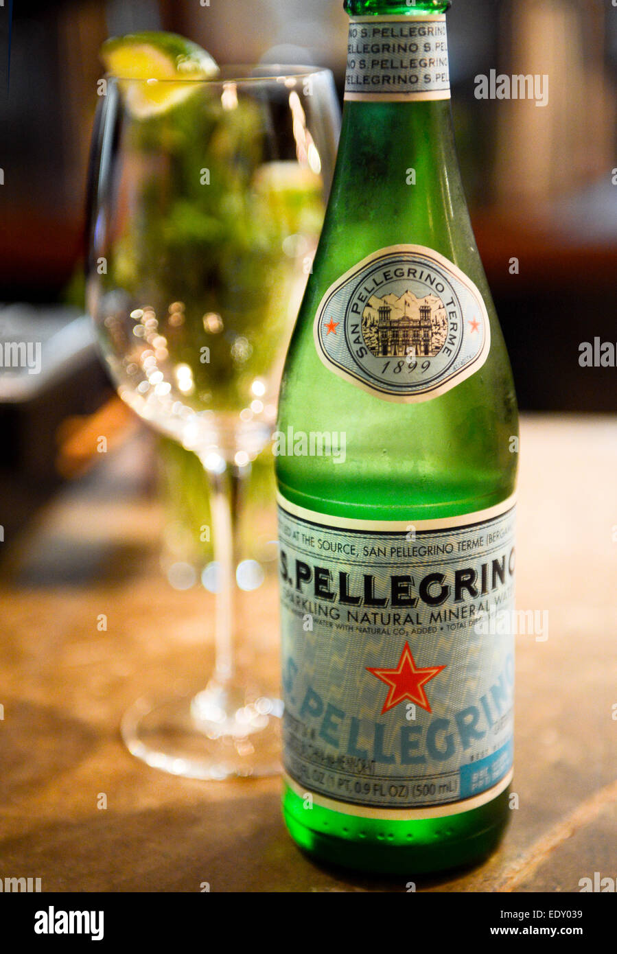 San Pellegrino Mineralwasser und Glas mit Limettenschnitz Stockfoto