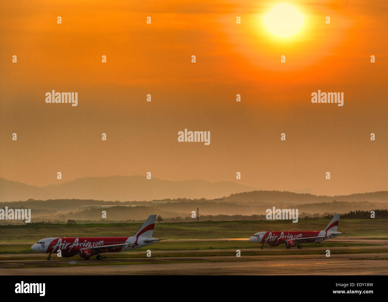 AirAsia Flugzeuge Flugzeuge Flugzeuge Rollen auf Rollbahn wartet Start-am Kuala Lumpur International Airport bei Sonnenaufgang. Stockfoto