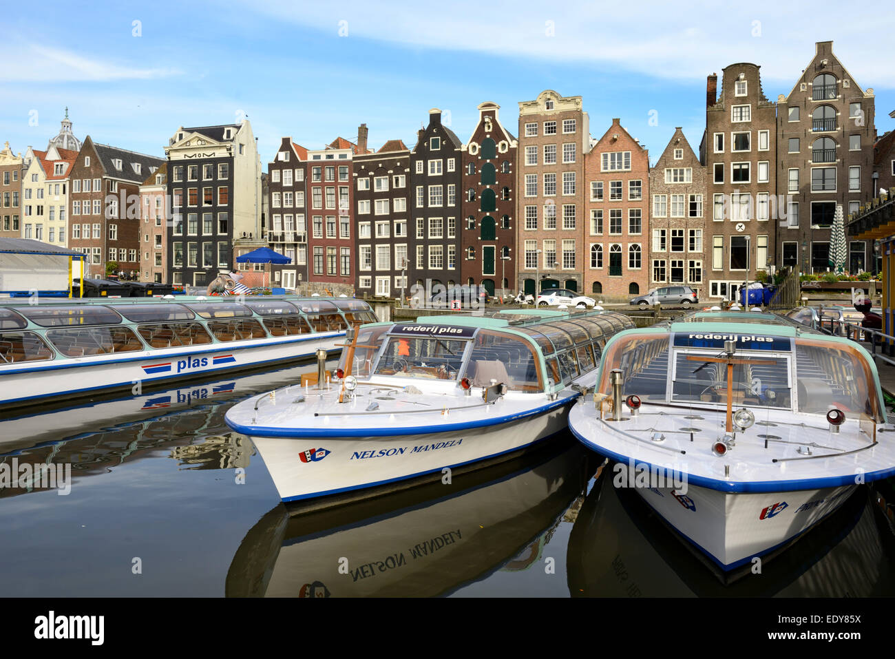 Sightseeing-Boote vertäut am Damrak-Kanal, mit Blick auf Warmoesstraat, Amsterdam, Noord-Holland, Niederlande, Europa Stockfoto