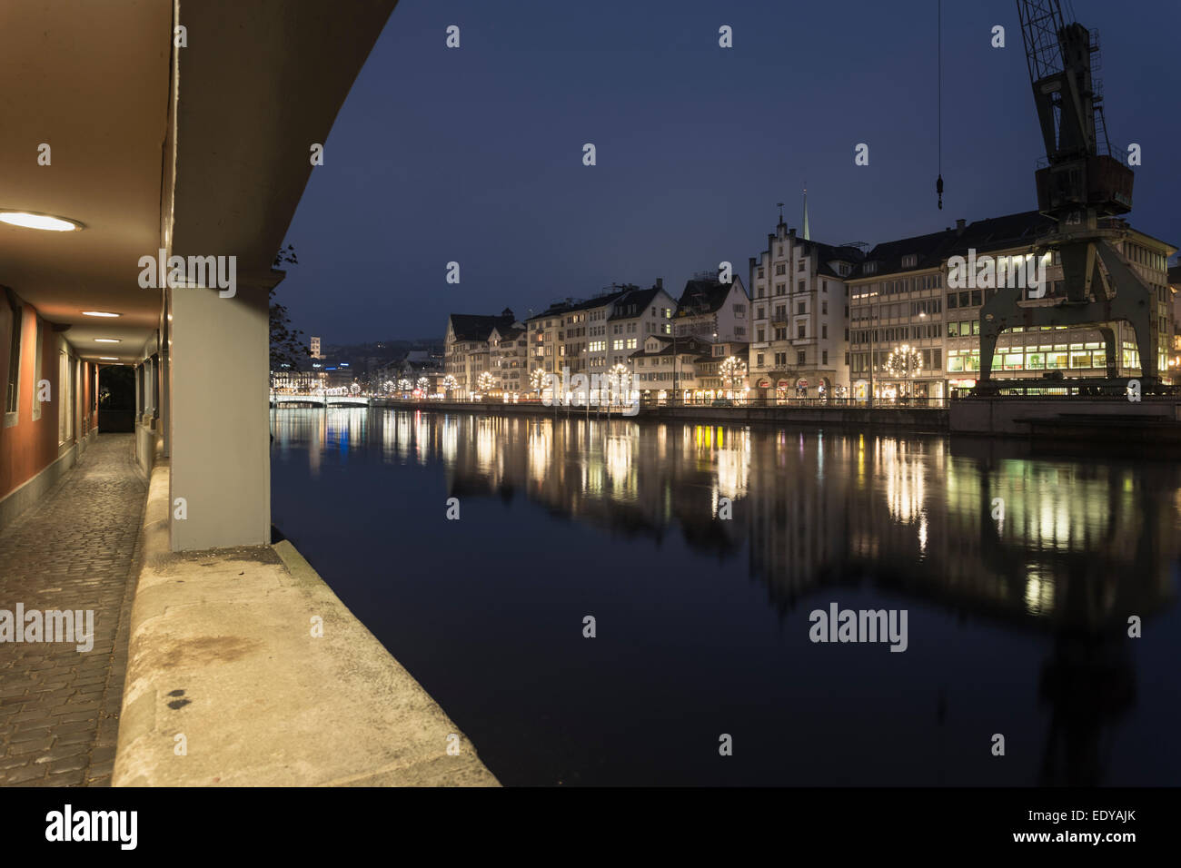 Zürich, alten Gebäude der Stadt spiegelt sich in der Limmat von einem überdachten Gang gesehen. Stockfoto