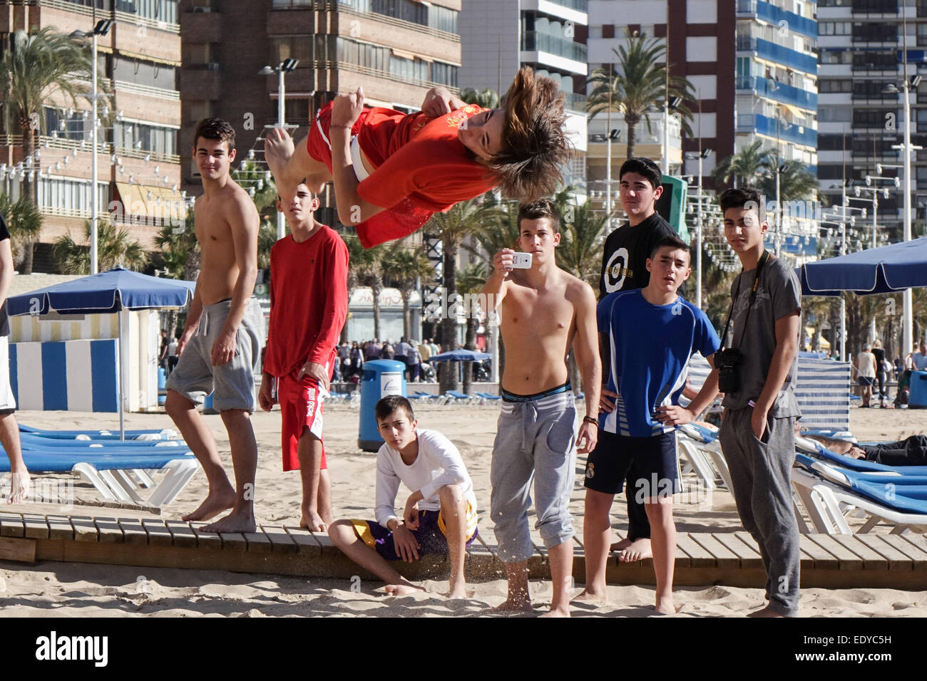 Tumbler Acrobat, akrobatische Jugend erscheinen zu gefrorenen Horizontal mit schnelle Verschlusszeit vor Freunden am Strand schweben Stockfoto