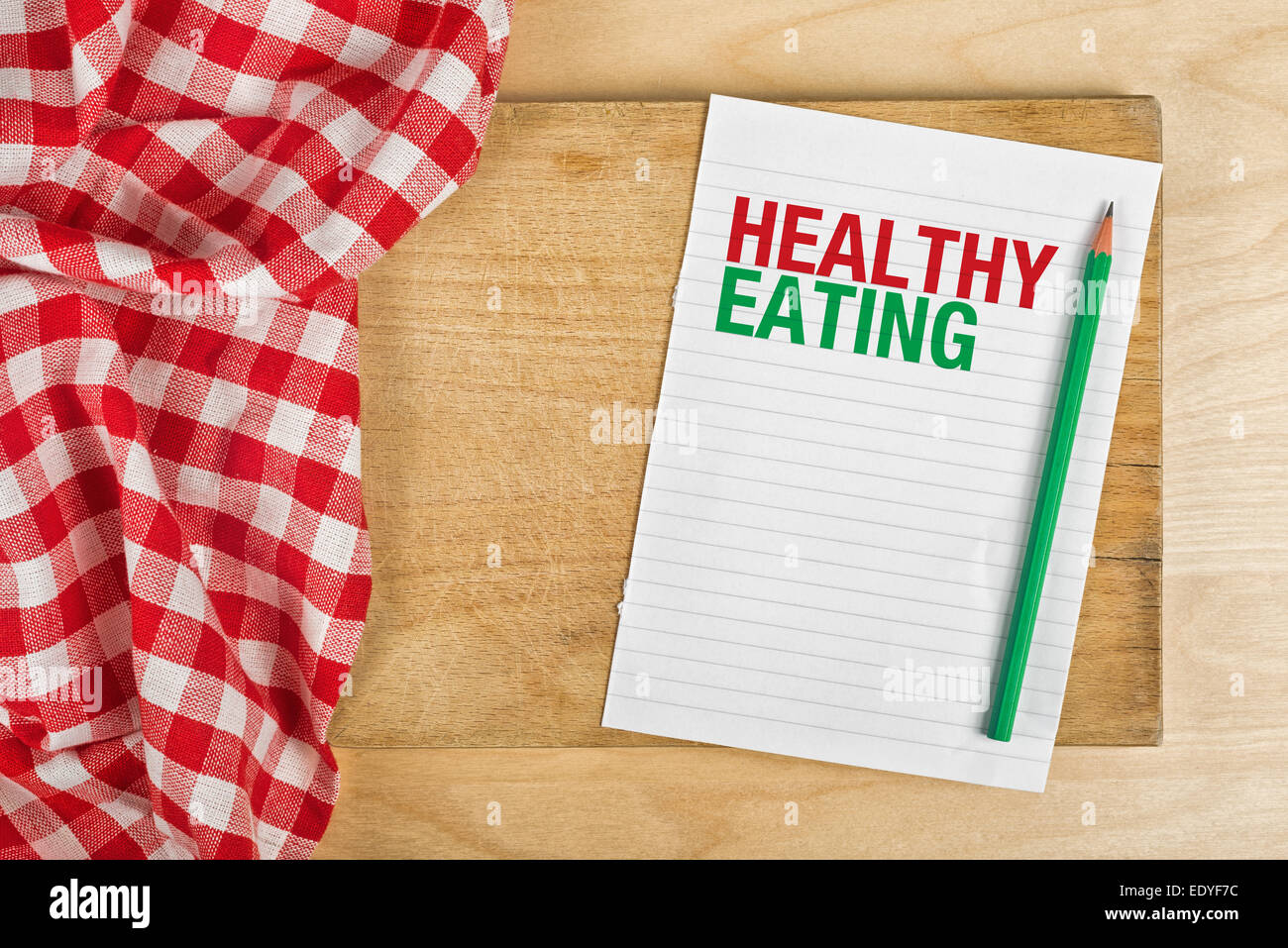 Gesund essen-Notizbuch mit Bleistift am Küchentisch, Konzept der Richtlinien für die richtige Ernährung mit Textfreiraum. Stockfoto