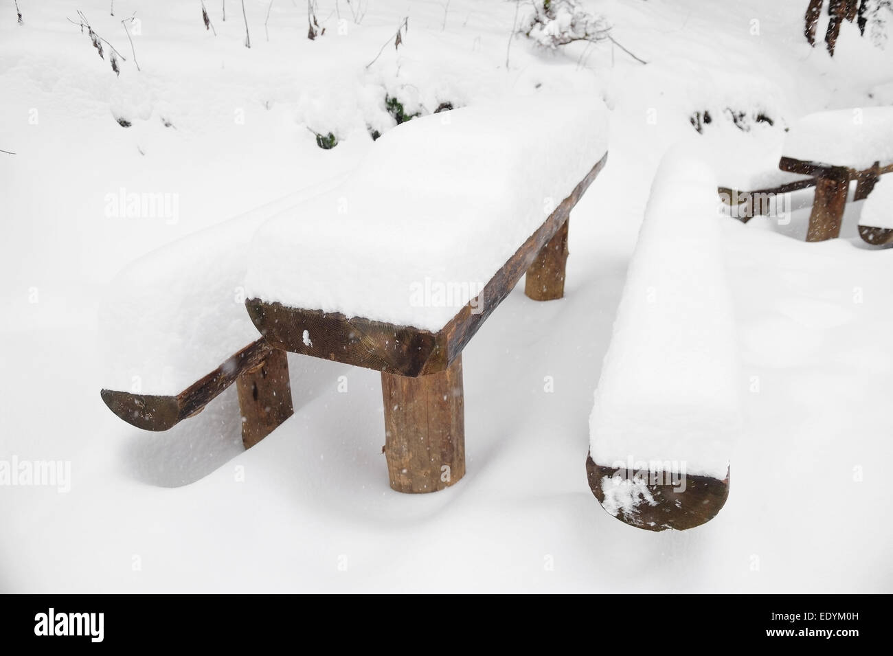 Hölzerne Picknick-Tisch mit Bänken nach starkem Schneefall Stockfoto