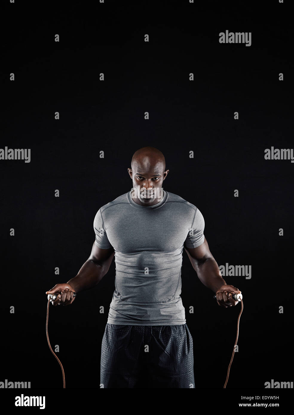 Studioaufnahme von männlichen afrikanischen Mann Springseil mit Textfreiraum. Porträt von muskulösen jungen Mann Training mit Seilspringen. Stockfoto