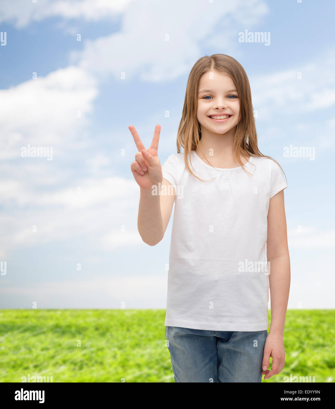 kleines Mädchen in weißen T-shirt zeigt Frieden Geste Stockfoto