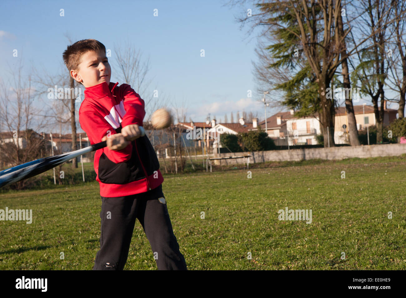 Kind mit rotem Plüsch, die Baseball spielt Stockfoto