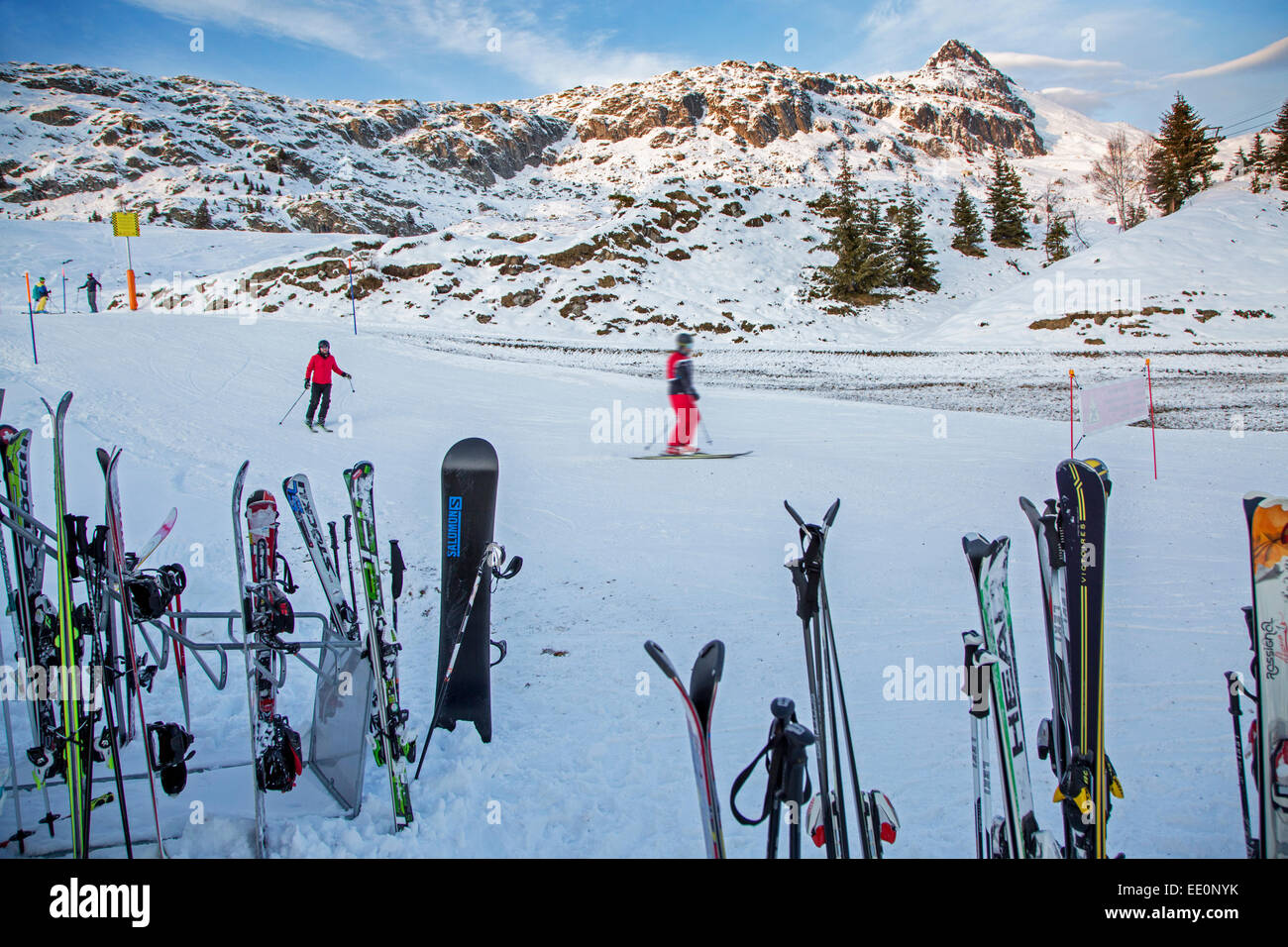 Ski und Snowboard im Schnee entlang der Skipiste im Wintersportort in den Alpen kleben Stockfoto