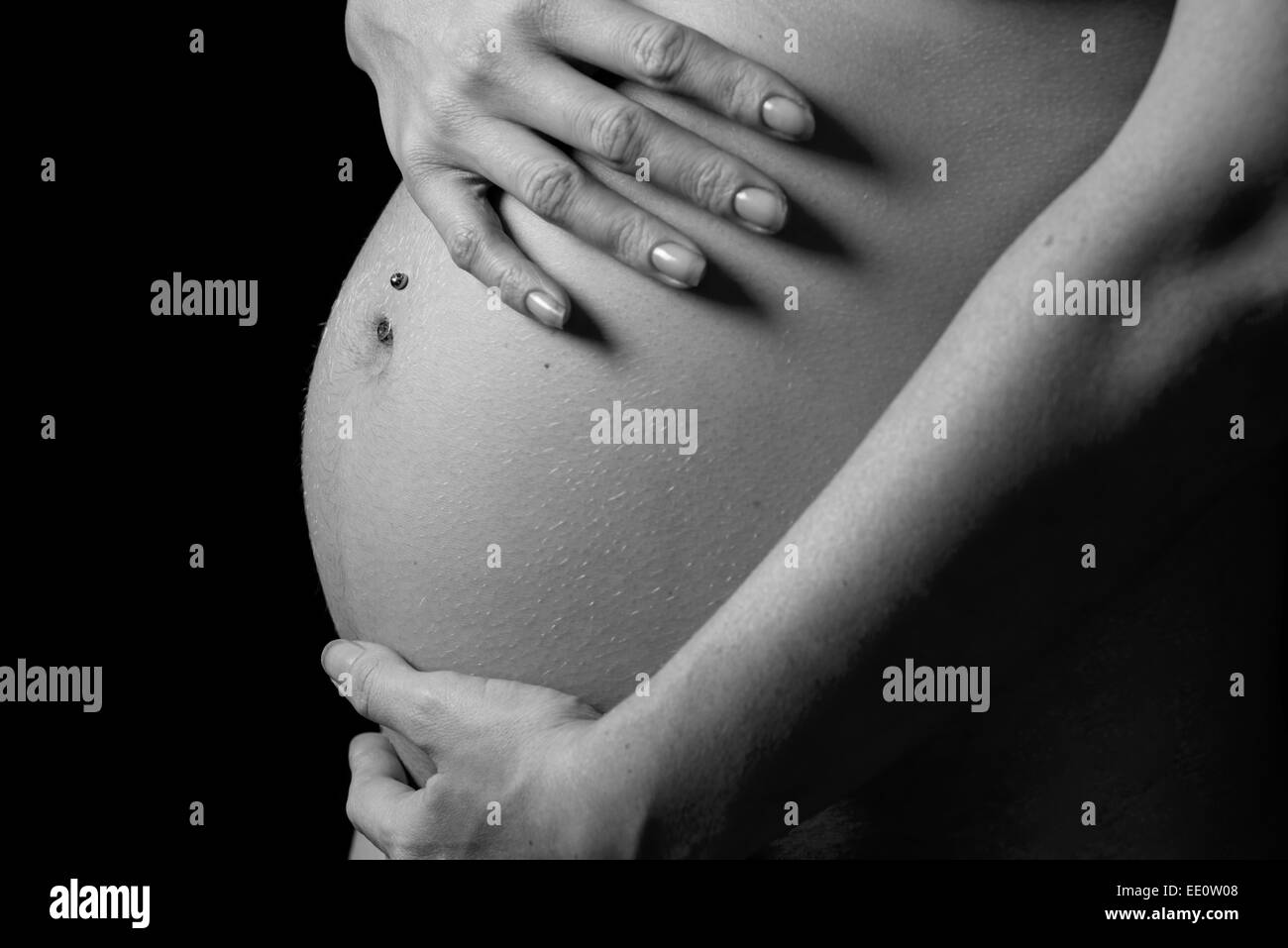 Eine Frau hält ihre Hände auf ihren Bauch oder Beule während schwanger. Stockfoto