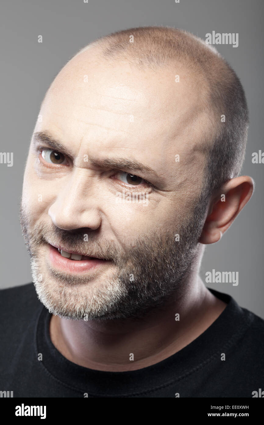 Porträt von skeptisch aussehender Mann auf grauem Hintergrund isoliert Stockfoto