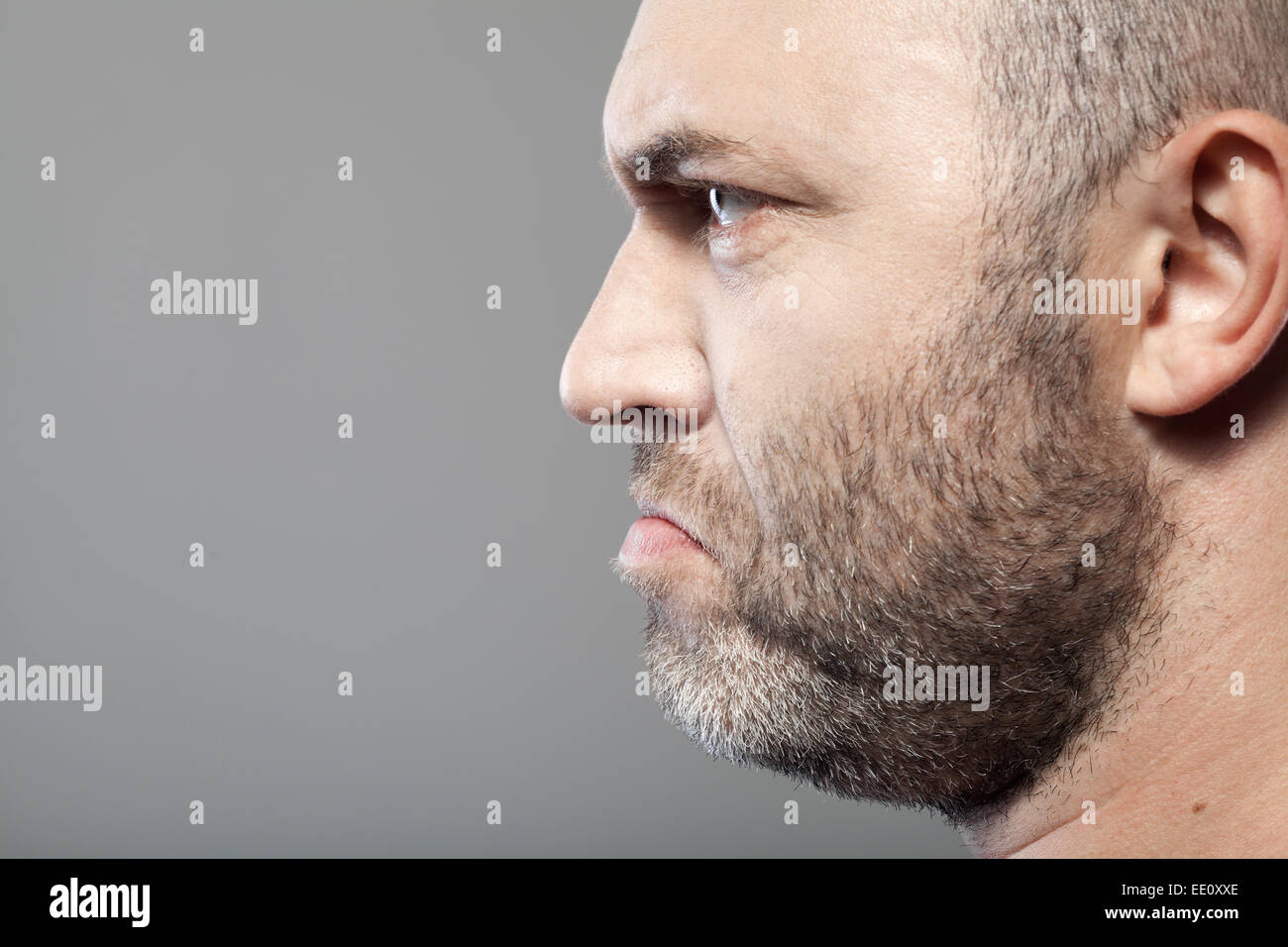Seite Porträt des düsteren Menschen isoliert auf grauem Hintergrund mit Exemplar Stockfoto