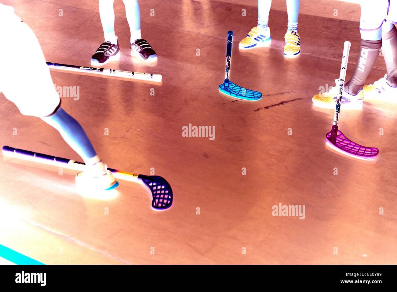 Kinder jungen Schüler spielen Floorball (Unihockey) entsprechen in Schule Turnhalle mit Kunststoff Hockeyschläger Stockfoto
