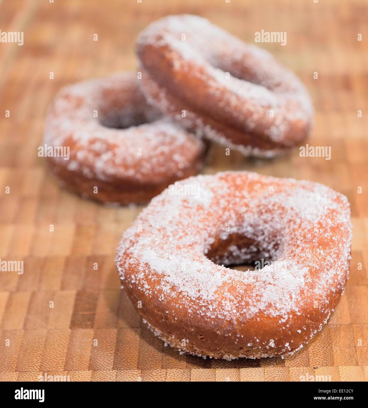 Süße Krapfen mit Holztablett mit Zucker bestreut. Stockfoto