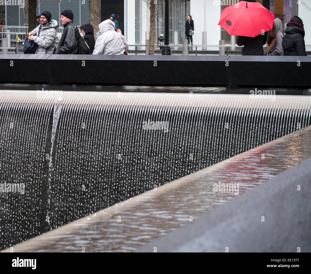 Memorial fällt Detail im Regen mit roten Regenschirm. Detail des Wasserfalls, aus denen sich ein wichtiger Teil der 9/11 Memorial. Stockfoto