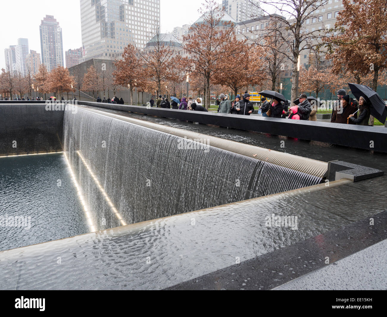 11. September Gedenkstätte am Ground Zero in den Regen. Touristen umgeben die tiefe Grube des fallenden Wassers, das den Hauptteil der bildet Stockfoto